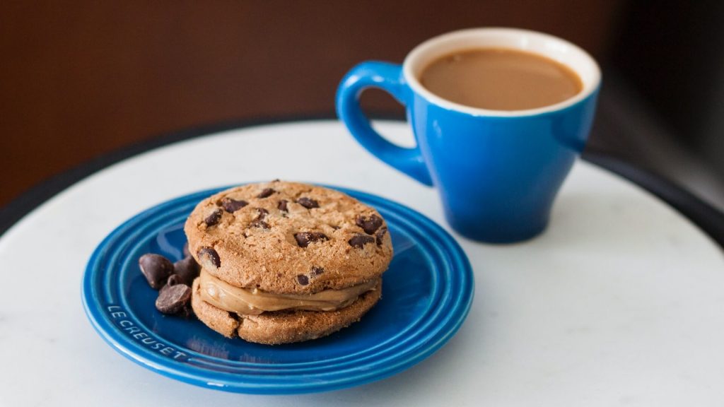 Una tazza di caffè caldo servita con biscotti al cioccolato per un momento di conforto